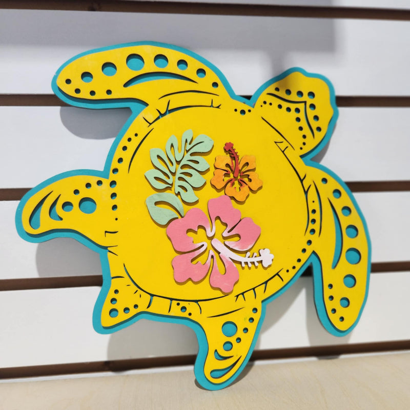Decorative turtle wall art with floral designs on a wooden background