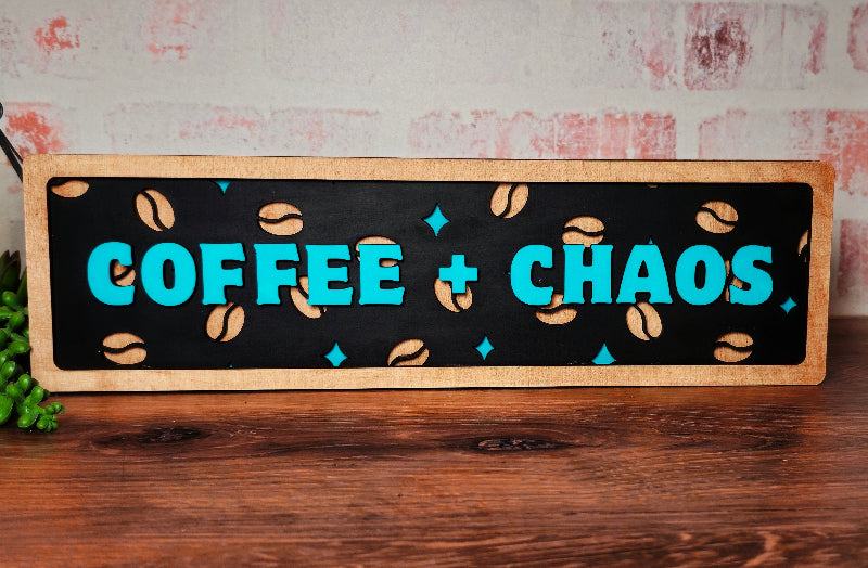 Wooden sign with 'COFFEE + CHAOS' text and coffee bean design on a rustic background