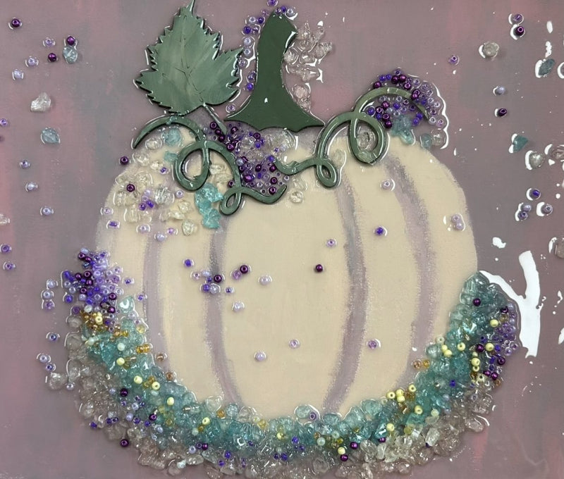 Decorative white pumpkin with crushed glass embellishments on a textured background