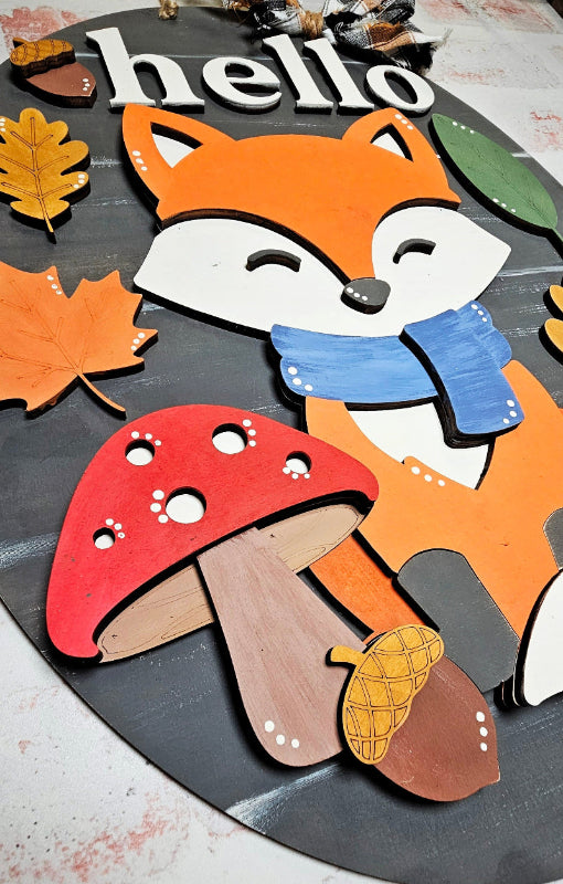 Wooden fox and mushroom with 'hello' text on a rustic background