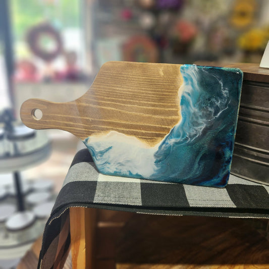 Wooden cutting board with a blue and white abstract design on a chair