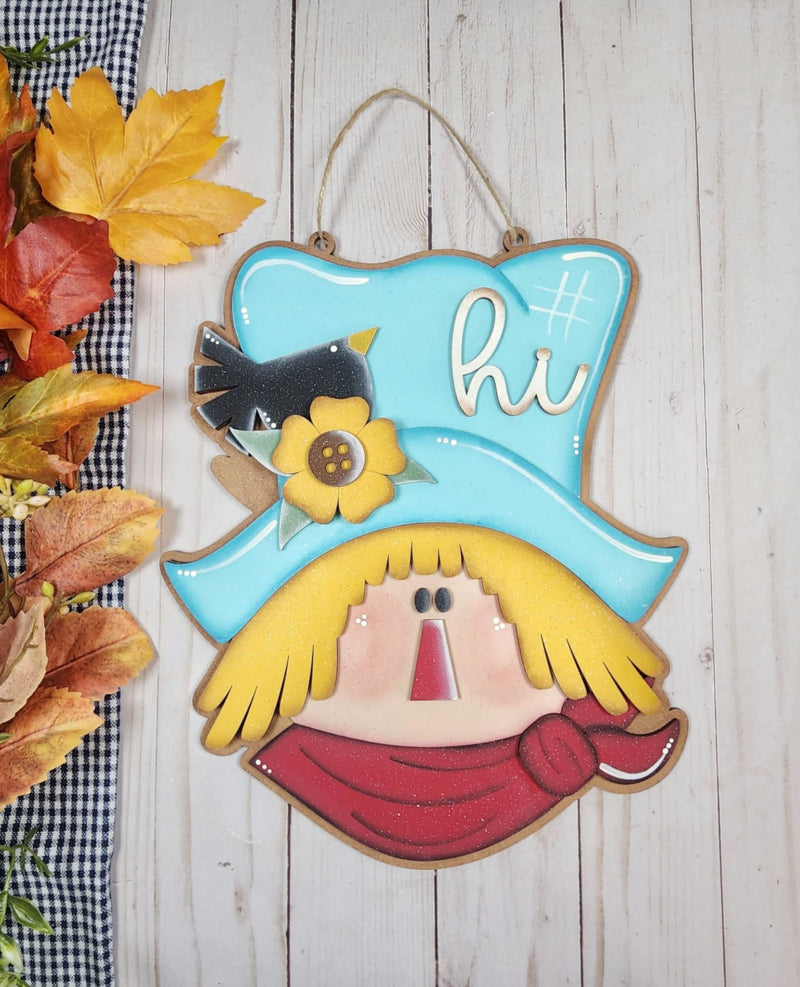 Wooden door hanger in the shape of a scarecrow head.