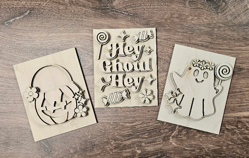 Three Halloween-themed stencils on a wooden surface