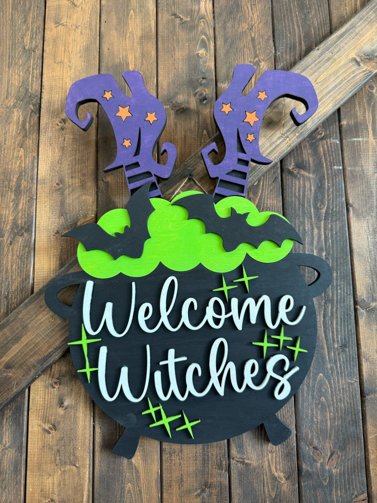 Halloween-themed decorative sign with 'Welcome Witches' text on a wooden background