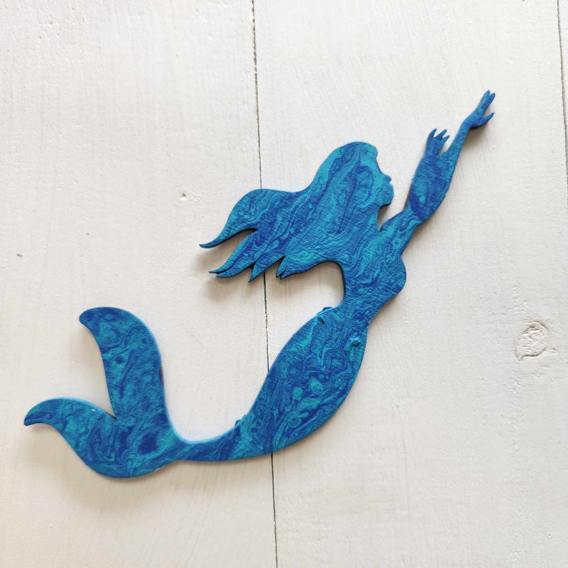 A blue wooden cutout in the shape of a mermaid designed for paint pouring crafts.