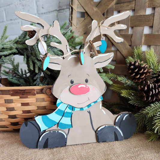boy reindeer sitting with scarf and lights on antlers