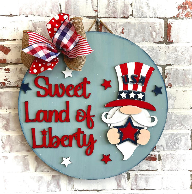 3D round door hanger with the text 'Sweet Land of Liberty' and a patriotic design featuring Uncle Sam, stars, and a red, white, and blue bow.