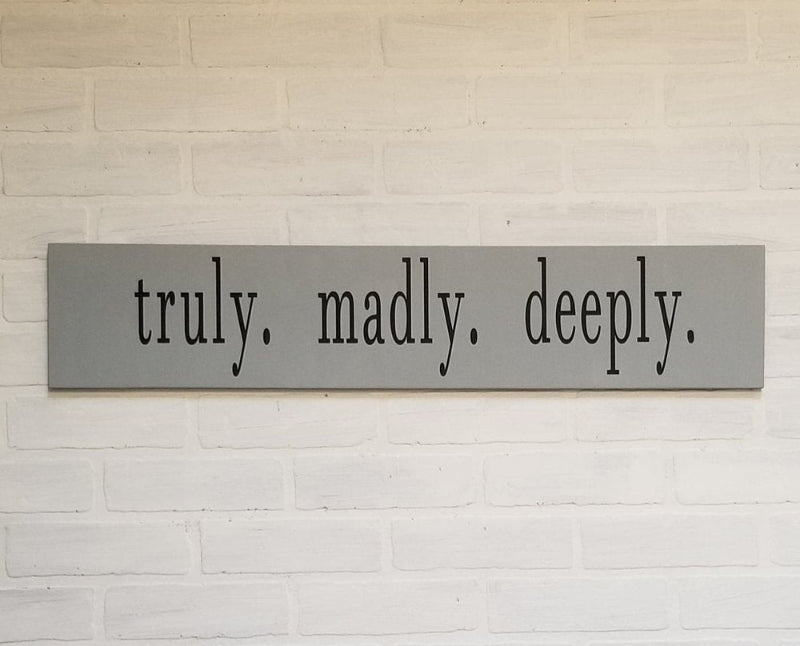 A gray plank design plaque with the text 'truly, madly, deeply' written in a large, bold font.