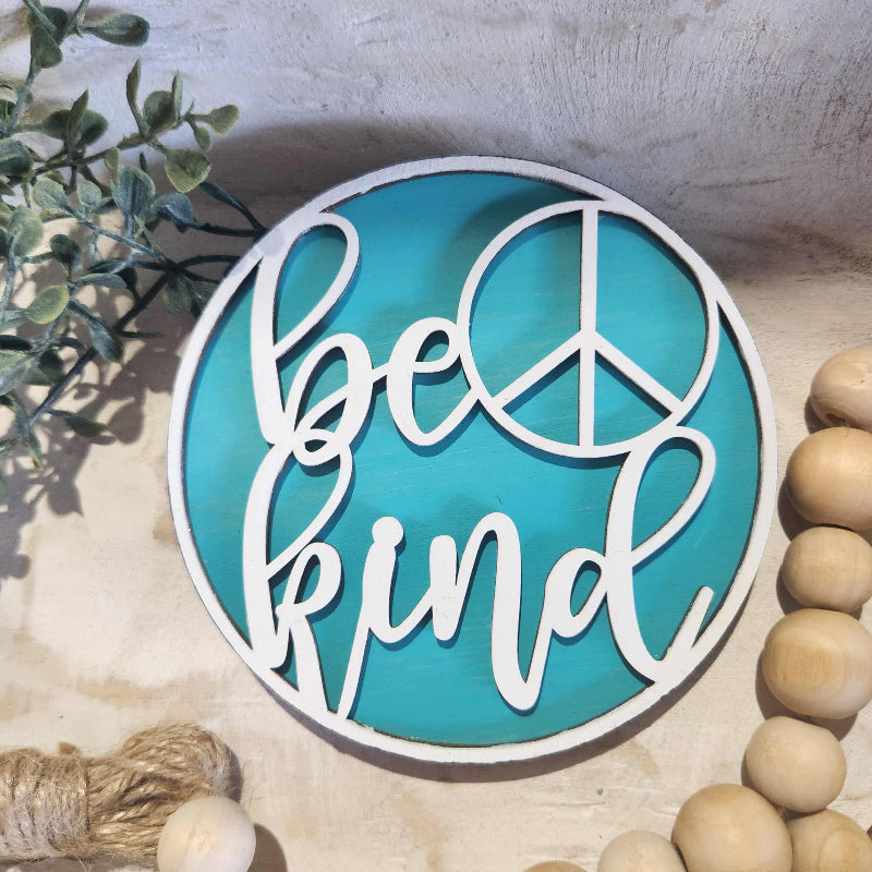 Decorative wall art with 'Peace' text on a blue background, surrounded by natural elements.