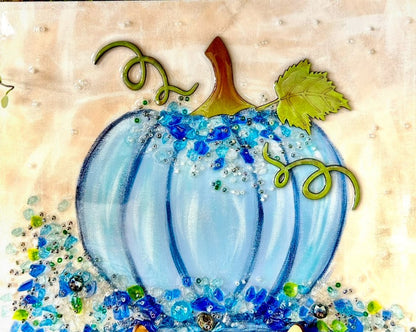 Decorative blue pumpkin with crushed glass decorative elements on a beige background