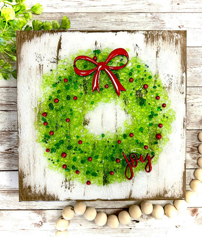 Crushed glass Christmas wreath with crushed glass ,red bow and 'Joy' text on a canvas painted background