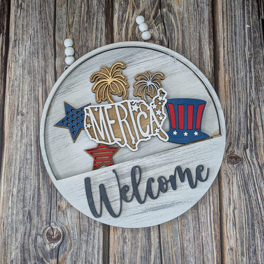 Decorative sign with 'America Welcome' text and American flag design on a wooden background