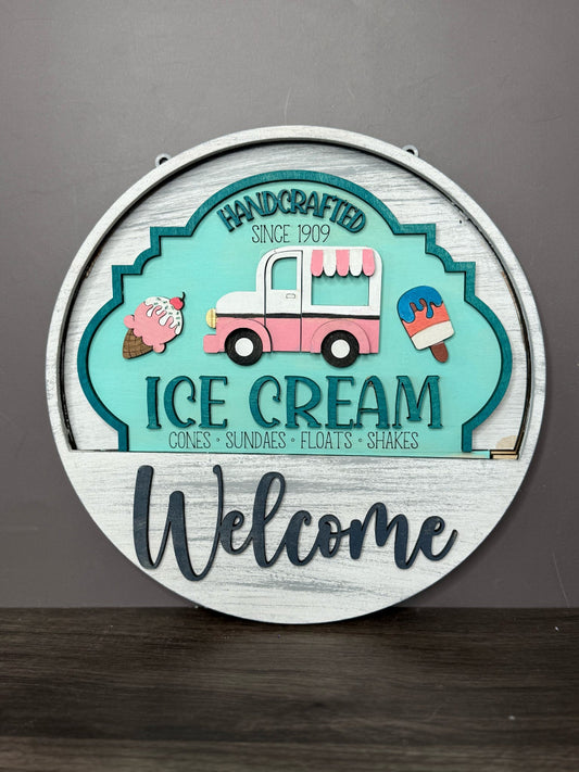 Decorative sign with ice cream truck design and 'Welcome' text on a gray background