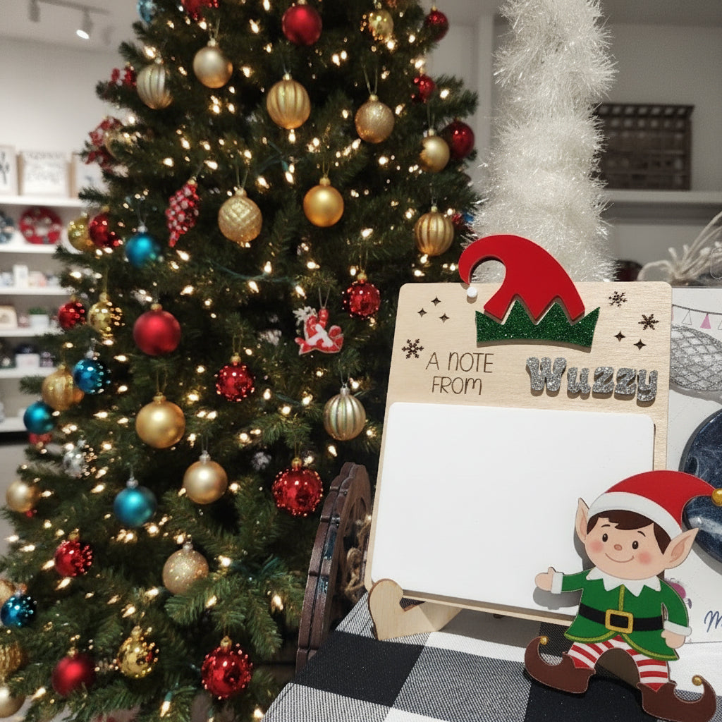 Wooden Christmas card with red and green design and text 'A Note From' on a blurred background.