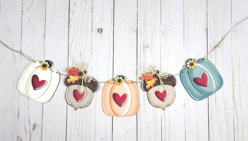 Wooden 3d pumpkins and acorns string together to make a fall banner