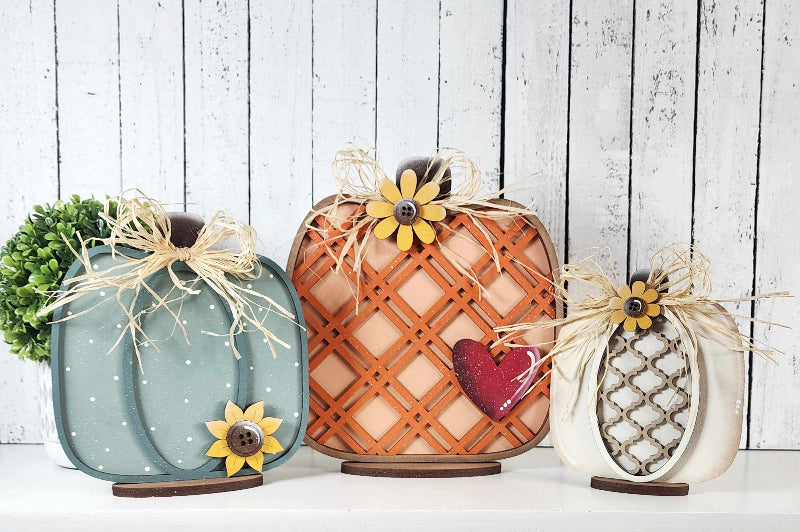 Trio of wooden pumpkins that stand up on bases. Variety of sizes