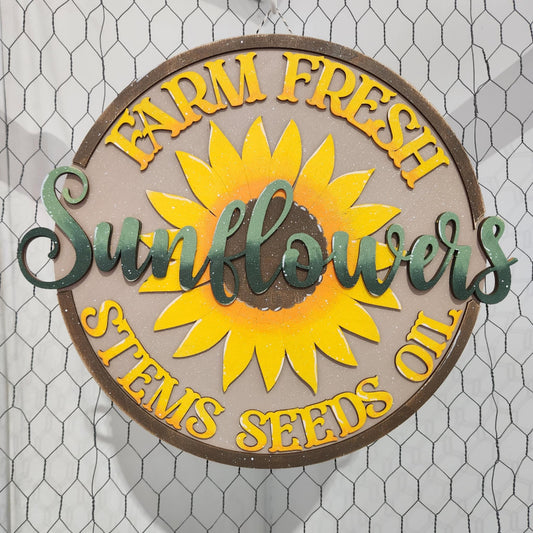 Decorative sign with sunflower design and 'Farm Fresh Sunflowers' text on a chicken wire background.