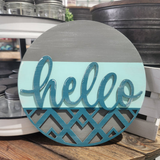 Round wooden sign with 'hello' text on a wooden surface