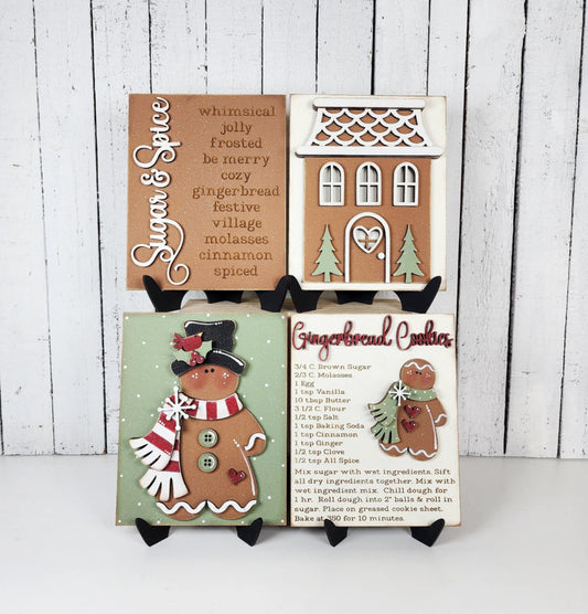 Decorative gingerbread-themed signs on a white surface with a wooden background.