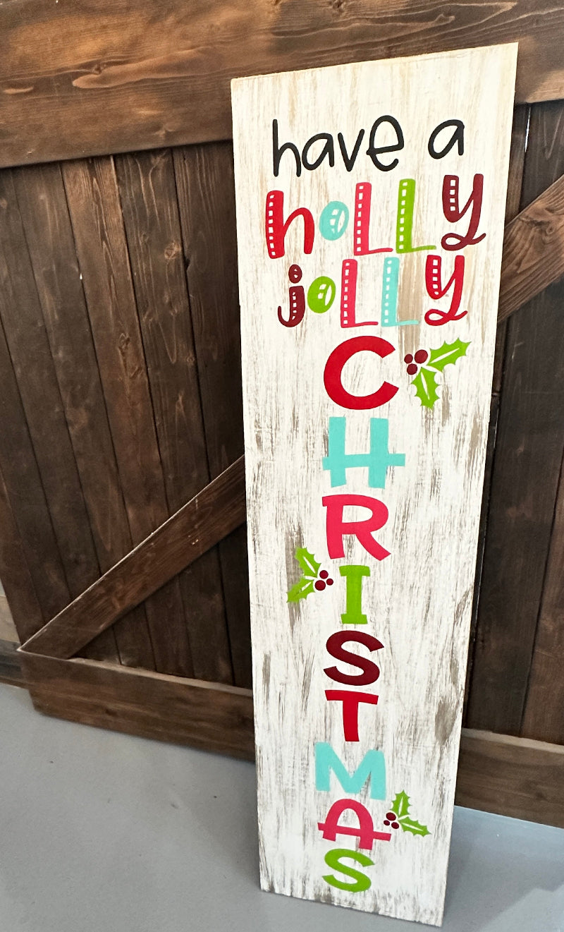 Wooden sign with colorful Christmas text against a wooden background
