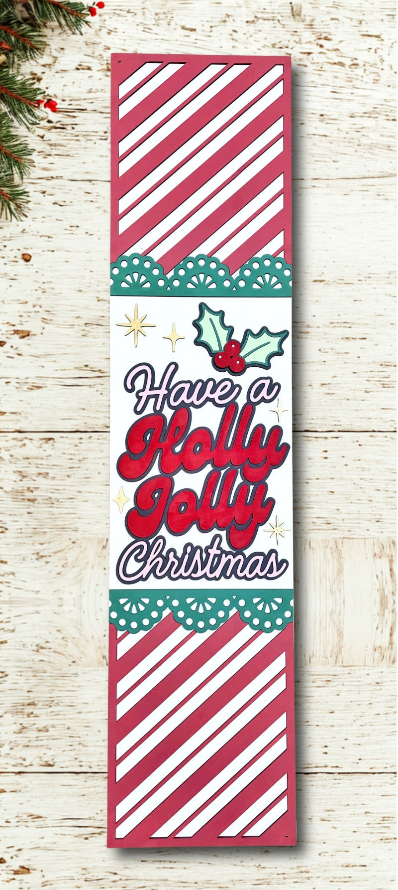 Decorative Christmas sign with 'Have a Holly Jolly Christmas' text on a wooden background.
