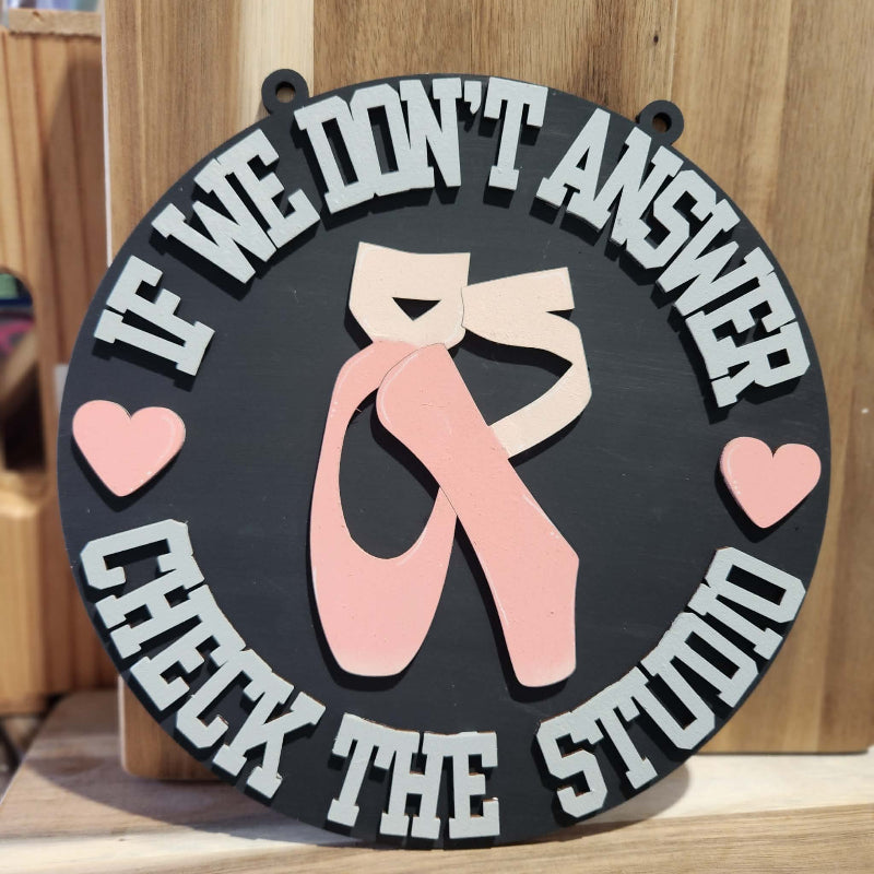 Decorative sign with ballet shoes and text on a wooden background