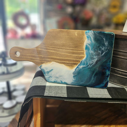 Wooden cutting board with a blue and white abstract design on a chair