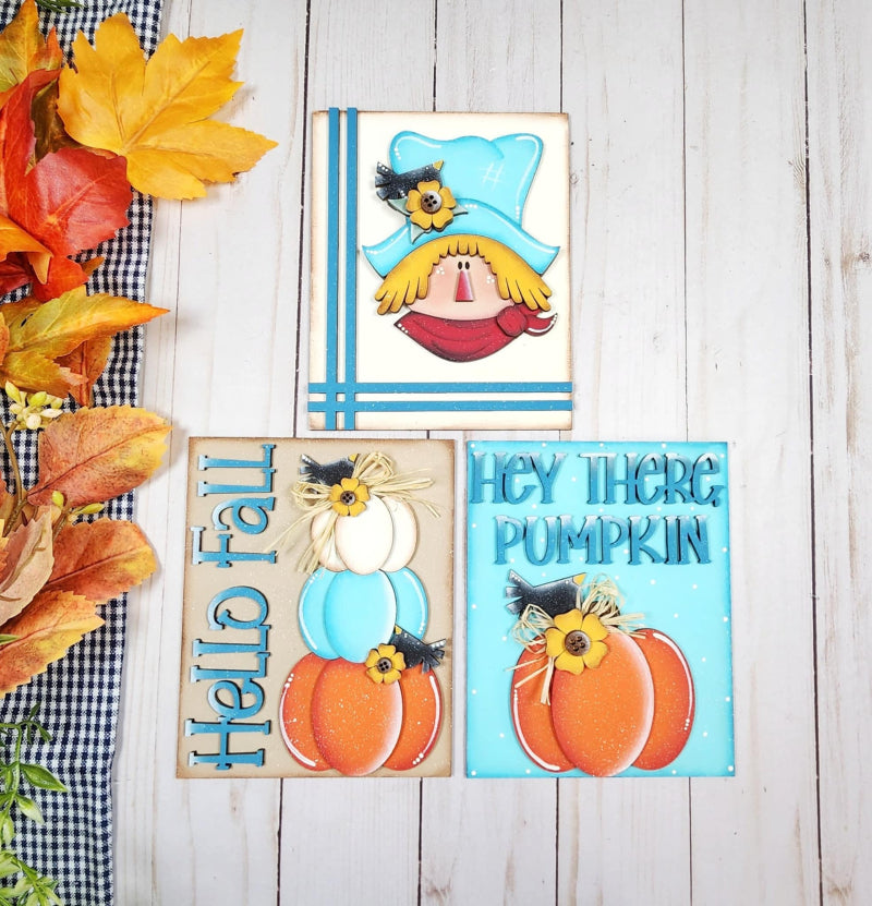 Scarecrow and pumpkins set on three mini wooden signs
