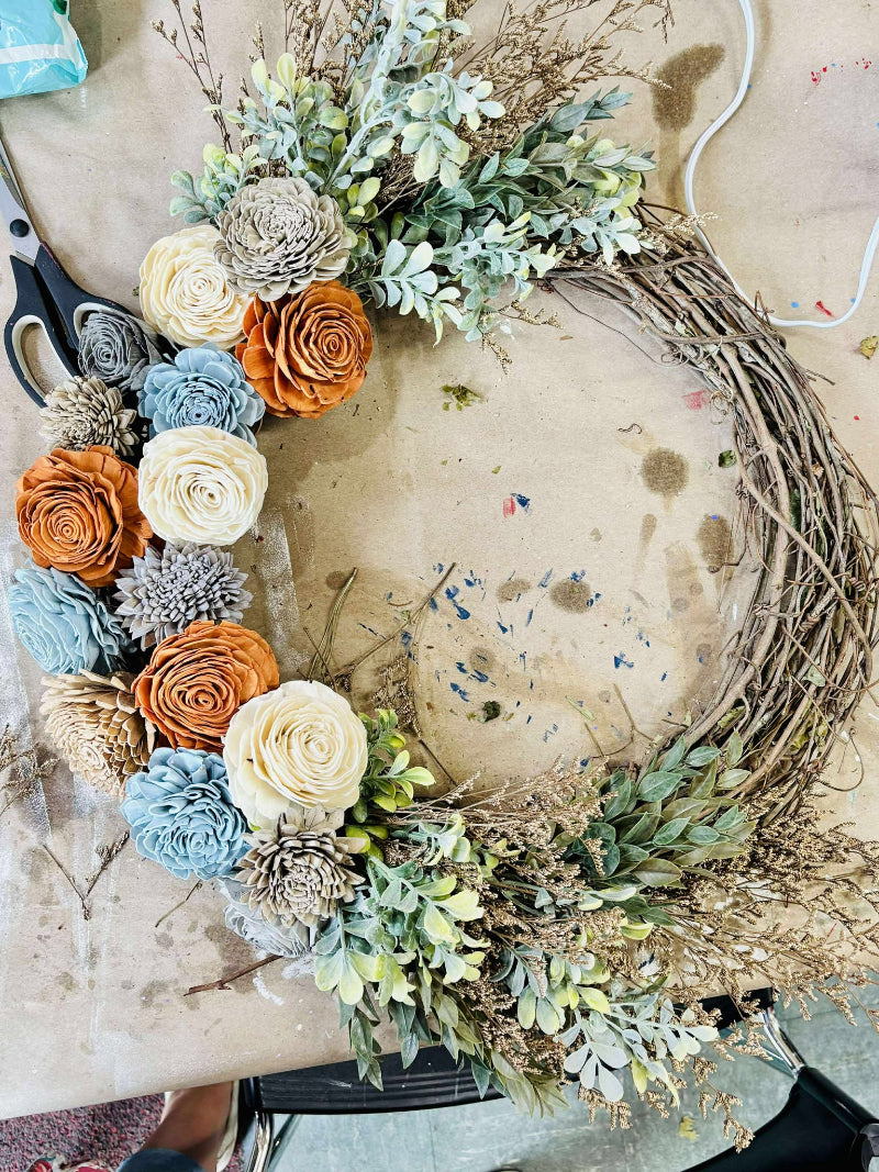 Decorative wreath with flowers and branches on a table