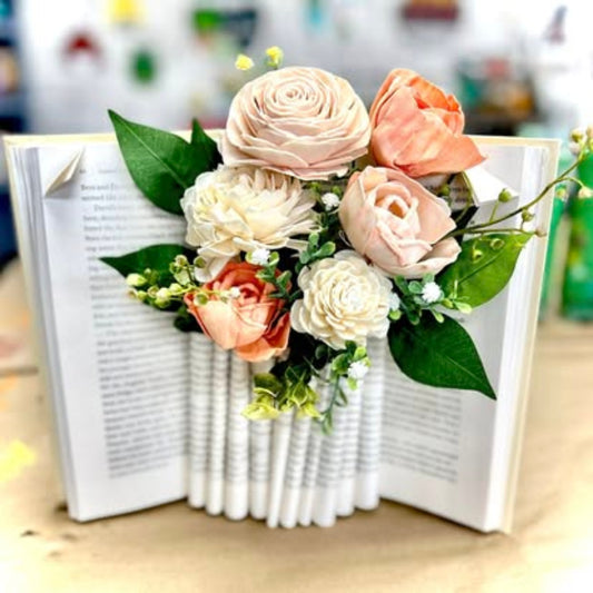 Floral arrangement in an open book on a wooden surface