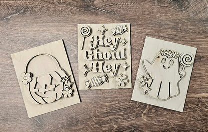 Three Halloween-themed stencils on a wooden surface