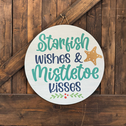 Decorative sign with 'Starfish wishes & Mistletoe kisses' text on a wooden background