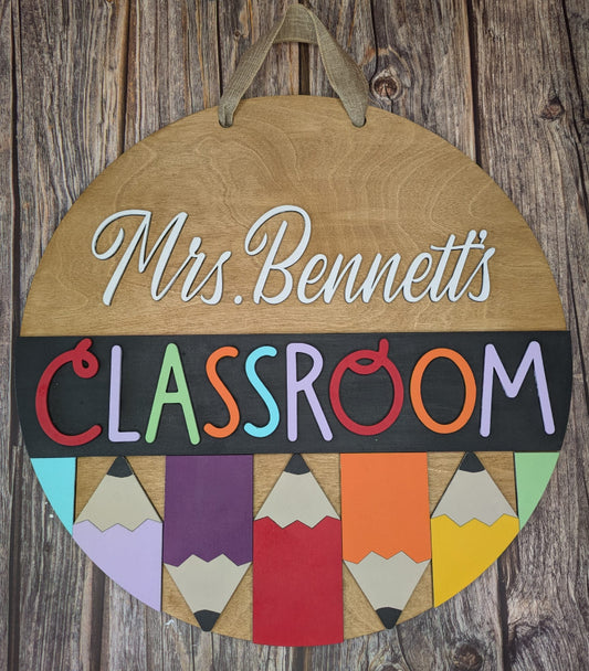 Wooden sign with 'Mrs. Bennett's Classroom' and colorful pencils on a wooden background