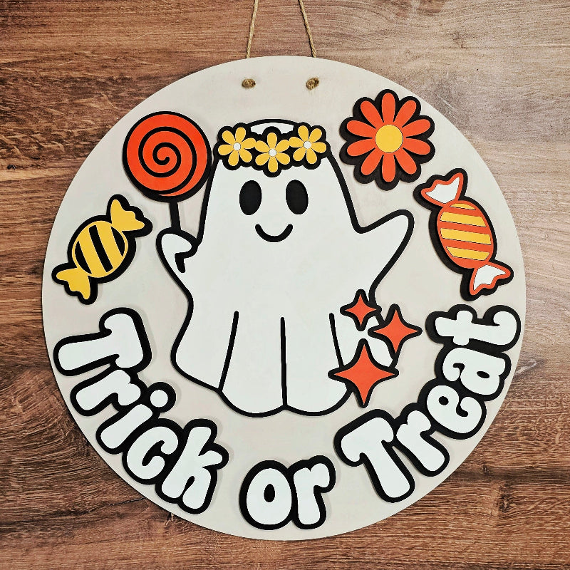 Circular Halloween-themed sign with a ghost, candies, and 'Trick or Treat' text on a wooden background.