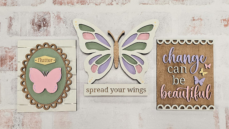Decorative wall art with butterflies and motivational phrases on a textured surface.