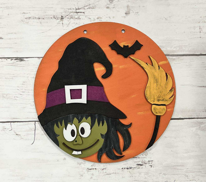 Halloween-themed decorative plate with a witch design on an orange background.