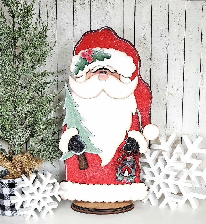 Wooden Santa Claus decoration with a tree and snowflakes on a wooden background