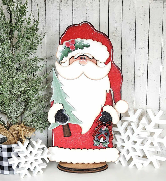 Wooden Santa Claus decoration with a tree and snowflakes on a wooden background