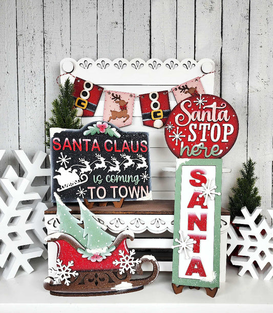 Collection of Christmas-themed decorative signs on a wooden background