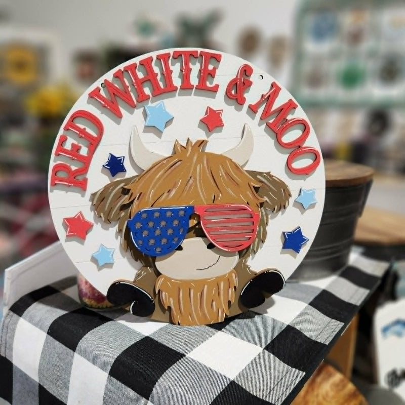 Decorative plate with a cow design wearing sunglasses and text 'Red White & Moo' on a checkered surface.