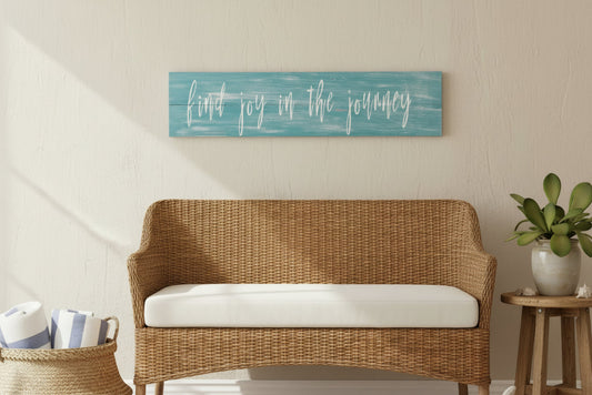 Wicker sofa with white cushion in a room with a motivational wall sign above it.